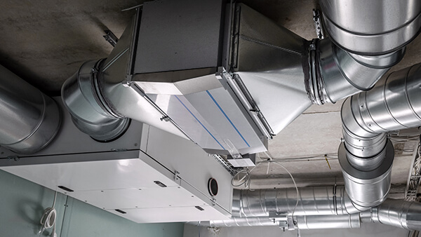 Professional using vacuum hose for AC duct cleaning